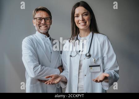 Lächelnde Ärzte stehen im Krankenhaus gegen die Wand Stockfoto