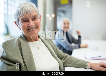 Glückliche ältere Frau, die den Schulkurs für Senioren besucht Stockfoto