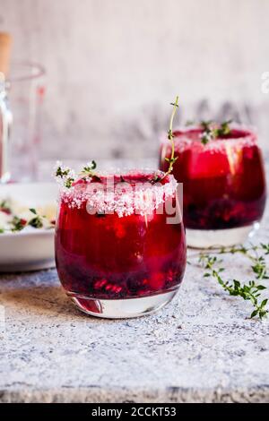 Wilde Beere Thymian zerschlagen mit wilden Beeren, Thymian, Tequila und Mineralwasser Stockfoto