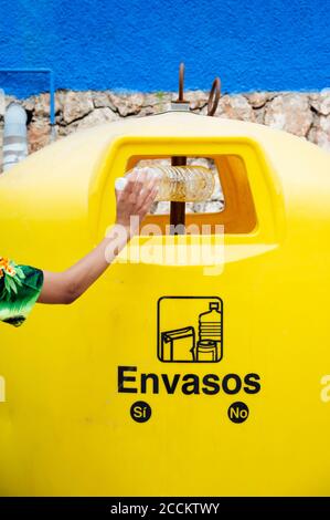 Nahaufnahme einer Frau, die die Plastikflasche in den Papierkorb legt Stockfoto