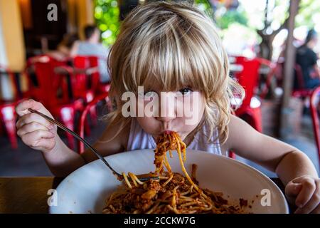 Mädchen essen Spaghetti im Restaurant Stockfoto