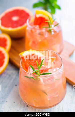 Gläser mit frischem Grapefruitsaft und Grapefruits Stockfoto