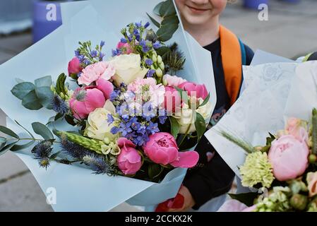 Ein Blumenstrauß für den ersten geliebten Lehrer am ersten September. Blumen für die letzte Glocke. Tag der Erkenntnis. Beginn des Schuljahres. Stockfoto