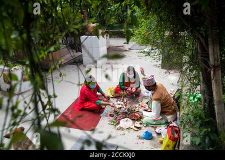 Kathmandu, Nepal. August 2020. Nepalesische Frauen, die Masken tragen, führen Rituale am Ufer des Bagmati Flusses auf Rishi Panchami durch.Rishi Panchami wird am letzten Tag von Teej beobachtet, wenn Frauen Sapta Rishi (Sieben Heilige) anbeten, um um Vergebung für Sünden zu bitten, die während ihrer Menstruationszeit während des ganzen Jahres begangen werden. Die hinduistische Religion betrachtet die Menstruation als eine Repräsentation von Unreinheit und Frauen ist es untersagt, während ihrer monatlichen Menstruation an religiösen Praktiken teilzunehmen. Kredit: SOPA Images Limited/Alamy Live Nachrichten Stockfoto