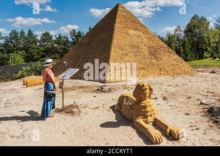 Krajno-Zagorze, Polen - 14. August 2020. Ein Tourist vor der Miniatur der Sphinx und Pyramide von Cheops in Sabat Krajno Amusement und Miniatur Stockfoto