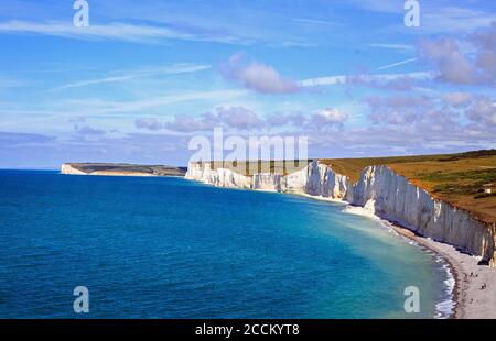 Die weißen Klippen der Seven Sisters in Birling Gap, in der Nähe von Beachy Head, Eastbourne, Großbritannien an einem schönen hellen Sommertag mit schöner Wolkenlandschaft. Stockfoto