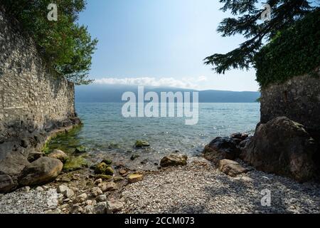 Kleiner Strand am Gardasee in Gargnano, Brescia, Italien, Panoramablick vom Westufer zur Seite von Verona Stockfoto