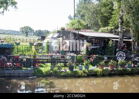 Fest vertäutes schmales Boot und Garten auf dem Macclesfield Kanal Höher Poynton Cheshire England Stockfoto