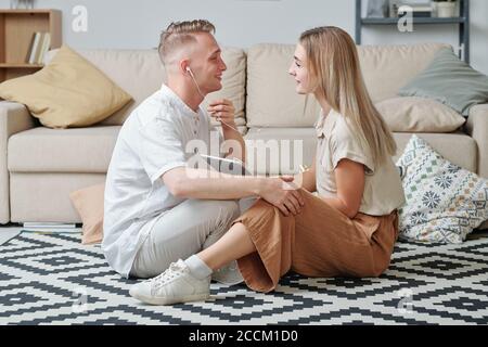 Glücklich junge amorous Paar in Casualwear Musik hören in Kopfhörer Stockfoto