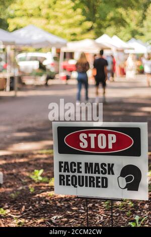 Auf einem Schild vor dem Bauernmarkt bei UNCA steht: 'STOP, GESICHTSMASKE ERFORDERLICH' in Asheville, NC, USA Stockfoto