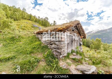 GEIRANGER, NORWEGEN - 2016. JUNI 12. Altes Holzhaus auf dem Berg Geiranger Fjord. Stockfoto