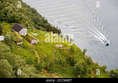 GEIRANGER, NORWEGEN - 2016. JUNI 12. Blick auf Geirangerfjord mit Passagierschiff und Skageflaa Bergfarm. Stockfoto