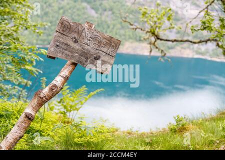 GEIRANGER, NORWEGEN - 2016. JUNI 12. Warnschild oberhalb Geiranger Fjord auf dem Wanderweg. Stockfoto