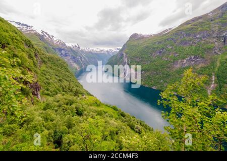 GEIRANGER, NORWEGEN - 2016. JUNI 12. Blick über den Geiranger Fjord mit grüner Landschaft Stockfoto