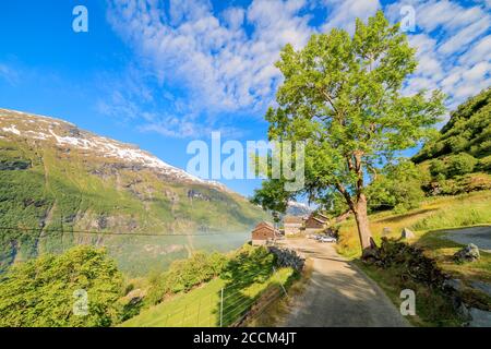 GEIRANGER, NORWEGEN - 2016. JUNI 13. Die schmale Straße nach Westeras Hof und Restaurant mit Blick auf Geiranger Fjord und Berge Stockfoto