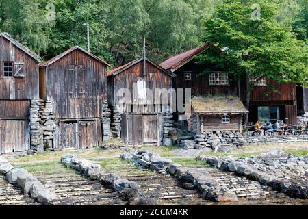 GEIRANGER, NORWEGEN - 2016. JUNI 14. Alte Holzhäuser am Meer vor Geiranger Stockfoto