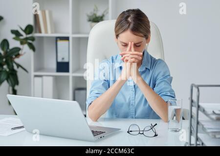 Eine moderne Geschäftsfrau, die beim Brainstorming die Hände im Gesicht hält Stockfoto