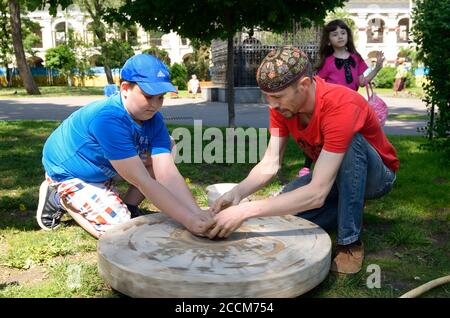 Männlicher Töpfer lehrt Junge von Rad werfen. Juni 12,2019. Kiew, Ukraine Stockfoto