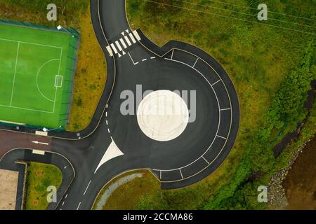 Luftaufnahme von Straßenmarkierungen an einem Kreisverkehr / Parkplatz in der Nähe des Sportkomplexes in Portree, Isle of Skye, Schottland. Stockfoto
