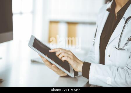Unbekannter weiblicher Arzt mit Tablet-Computer in der Klinik. Perfekter medizinischer Service im Krankenhaus. Medizinkonzept Stockfoto