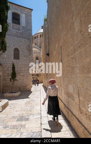 Israel, Jerusalem. Einheimische Frau in typischer Kleidung in der historischen engen Gasse in der Altstadt. Stockfoto