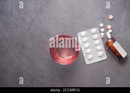 Draufsicht auf Pillen Pille Behälter und Wasser Glas auf Tabelle Stockfoto