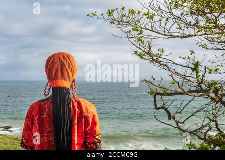 Afrikanische Frau trägt orange traditionelle Kleid aus Ghana schaut über Der Horizont in Takoradi Ghana Westafrika Stockfoto