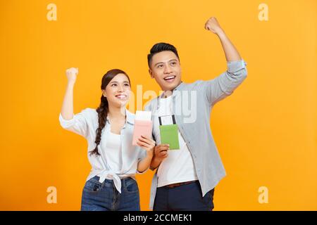 Glückliches Paar mit Pässen und Flugkarten isoliert auf gelb Stockfoto