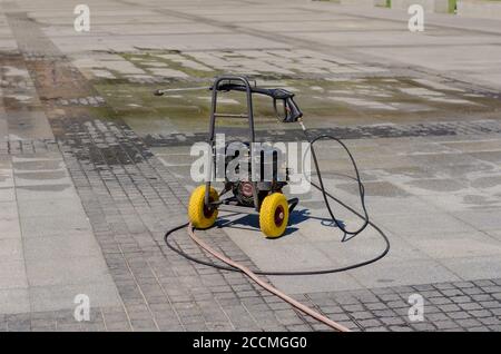 Elektrischer Druckwäscher auf einer Stadtstraße. Reinigungsservice für die öffentlichen Bereiche. Die Arbeit der Gemeinde. Ohne jemanden. Stockfoto