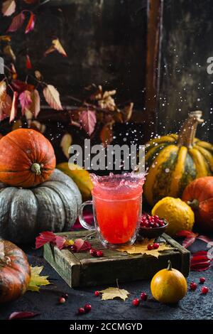 Stillleben im Herbst. Kreatives Konzept. Beeren schweben über einer Tasse heißen Getränks Stockfoto