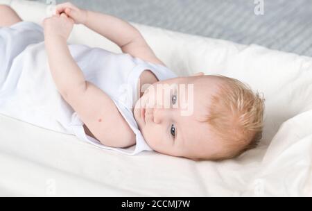 Ein schönes Neugeborenes mit Spuren der BCG-Impfung-der TB-Impfstoff-auf seinem Arm. Das Baby liegt auf dem Wickeltisch und schaut weg Stockfoto