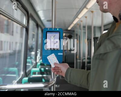 Man validiert Tageskarte in einer Straßenbahn in Helsinki, Finnland Stockfoto