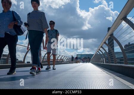 Die Menschen wandern und radeln über die Millennium Bridge, die berühmte wackelige Fußgängerbrücke über die Themse von St. Pauls zur Tate Modern in London Stockfoto