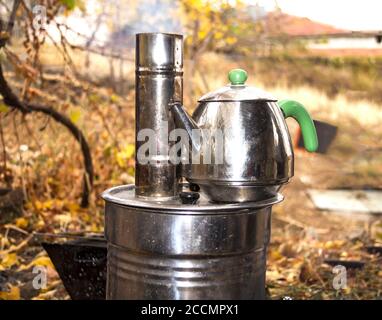 Tee am Lagerfeuer im Park zubereiten Stockfoto