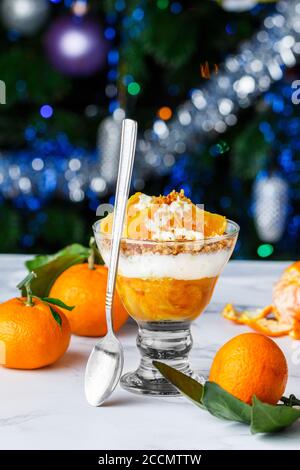 Zitrusfrucht mit Mandarinen, Keksbröseln, Vanille und Schlagsahne. Köstliches hausgemachtes mehrlagiges Dessert für Feinschmecker. Weihnachten. Neujahr. Wählen Sie Stockfoto