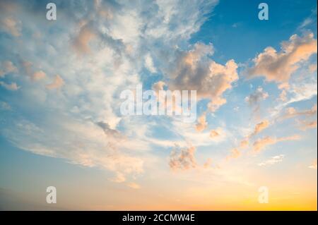 Schöner Sommerhimmel voller Wolken bei Sonnenuntergang zur goldenen Stunde. Interessante warme Farben am Horizont. Stockfoto