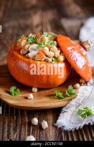 Gerösteter Hokkaido-Kürbis gefüllt mit Kichererbsen, Quinoa, Pilzen und Pfeffer Stockfoto