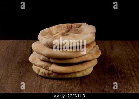 Verschiedene Pita Brote auf einem Holzbrett mit schwarzem Hintergrund Stockfoto