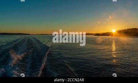 Boot Wake durch Rosario Strait, Washington, bei Sonnenuntergang Stockfoto