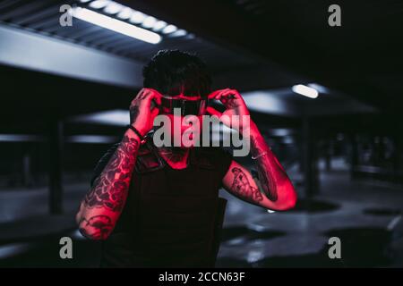 Mann in der Nachtstadt. Porträt eines Mannes mit asiatischem Auftritt in einer Neonstadt. Stockfoto