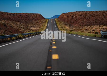 Landschaft mit orangefarbenen Felsen, Himmel mit Wolken und Asphaltstraße im Sommer. Asphalt Textur, Weg Hintergrund. Stockfoto