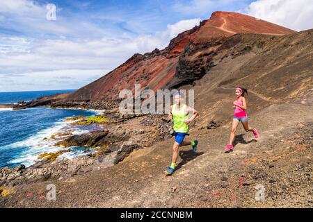 Trailrunning Paar Läufer Rennen auf Bergpfad in vulkanischen Felsen Natur Landschaft im Sommer im Freien. Ultra-Running-Rennen Stockfoto