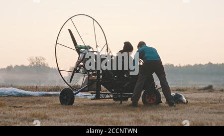 Paramotorgliding. Zwei Männer bereiten sich auf das Tandem-Paramotorgliding vor. Hochwertige Fotos Stockfoto