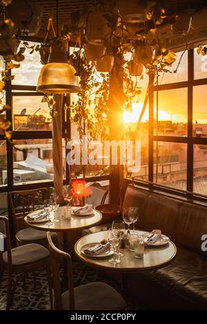 Tisch im Restaurant serviert für ein romantisches Abendessen auf der Dachterrasse bei Sonnenuntergang Licht. Liebe in der Luft. Stockfoto