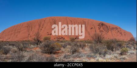 Ungewöhnlicher Panoramablick auf das versteckte Gesicht des Mount Uluru. Erodierte Wand mit Flecken. Heiliger Ort für Urmenschen. Wahrzeichen Australiens Stockfoto