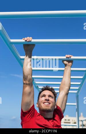 Fitness Monkey Bars Mann Training Arme Muskeln im Dschungel Fitnessstudio im Freien im Sommer. Athlet trainieren Greifen Klettern auf Leiter Ausrüstung beim Sport Stockfoto