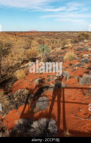 Schatten zweier Touristen, die Fotos vom Mount Uluru machen, einem heiligen Wahrzeichen der Aborigines in Zentralaustralien, Northern Territory NT, Australien Stockfoto