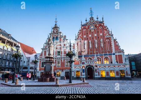 Riga, Lettland. Panorama der Rathausplatz, beliebter Ort mit berühmten Sehenswürdigkeiten in helle Beleuchtung am Abend im Winter in der Dämmerung. Winter Neue Stockfoto