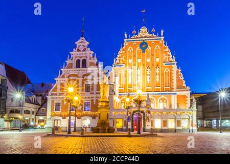 Riga, Lettland. Panorama der Rathausplatz, beliebter Ort mit berühmten Sehenswürdigkeiten in helle Beleuchtung am Abend im Winter in der Dämmerung. Winter Neue Stockfoto