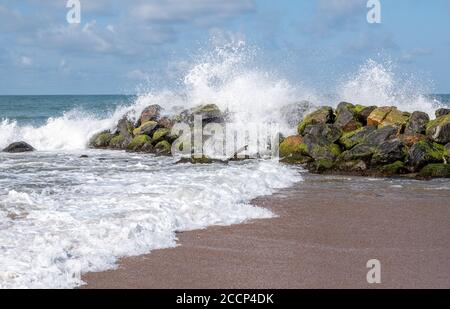 Wellenabstürze auf einem Wellenbrecher an einem Strand in Sri Lankas Stockfoto